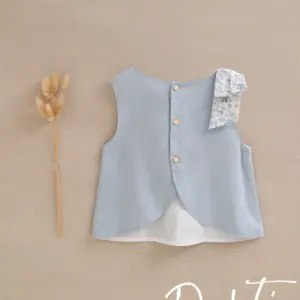 blusa niña azul con lazada de flores en hombro y espalda abierta