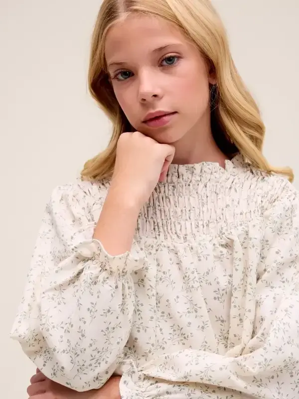 Blusa de niña color crudo con estampado floral verde